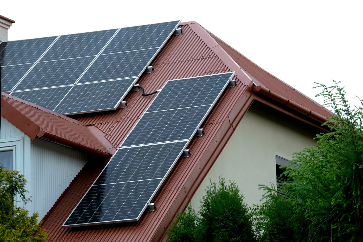 Installing a Solar Cell on a Roof. Solar panels on roof. Historic farm house with modern solar panels on roof and wall. High quality photo